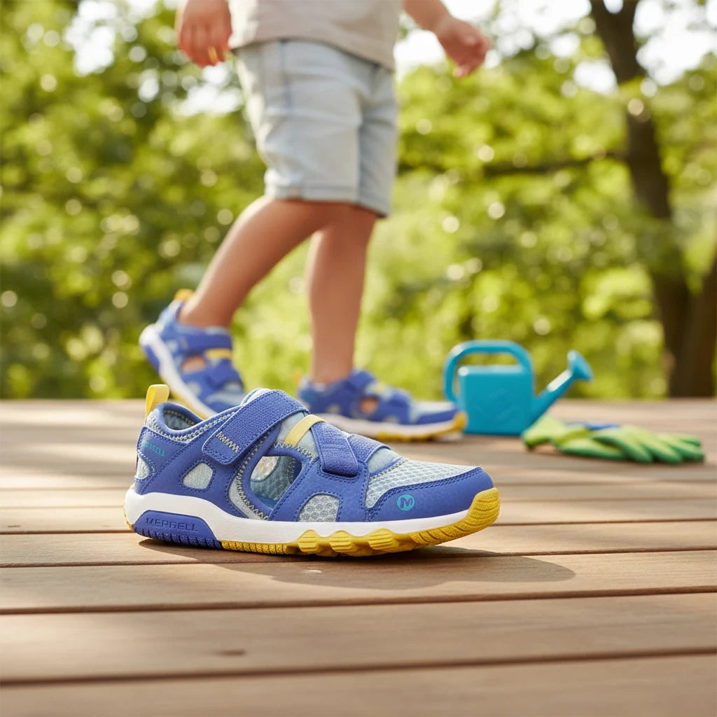 Allen's Bootery Hydro Free water sandals for kids in blue and yellow with a flexible outsole on a wooden deck