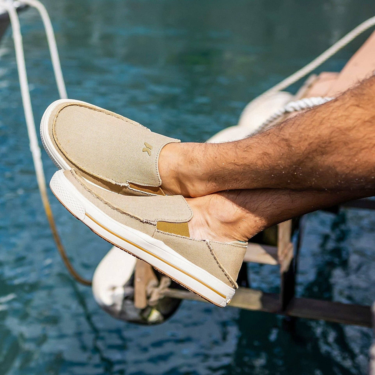 Allen's Bootery Men's tan canvas slip-on boat shoes with fish print insoles and non-marking rubber soles.