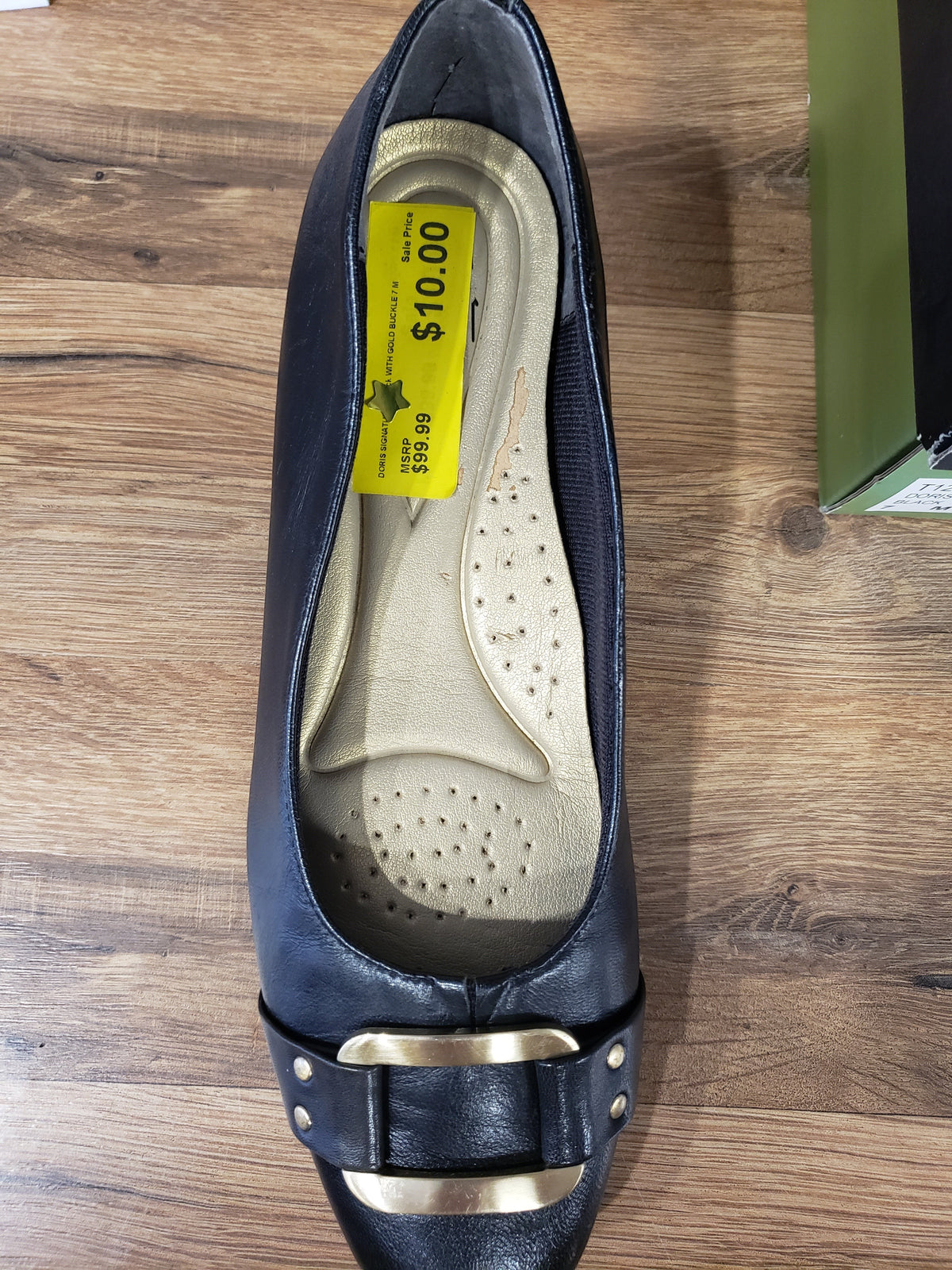Allen's Bootery Trotters Doris black dress shoe with gold buckle and 1.25-inch heel, top-down view.