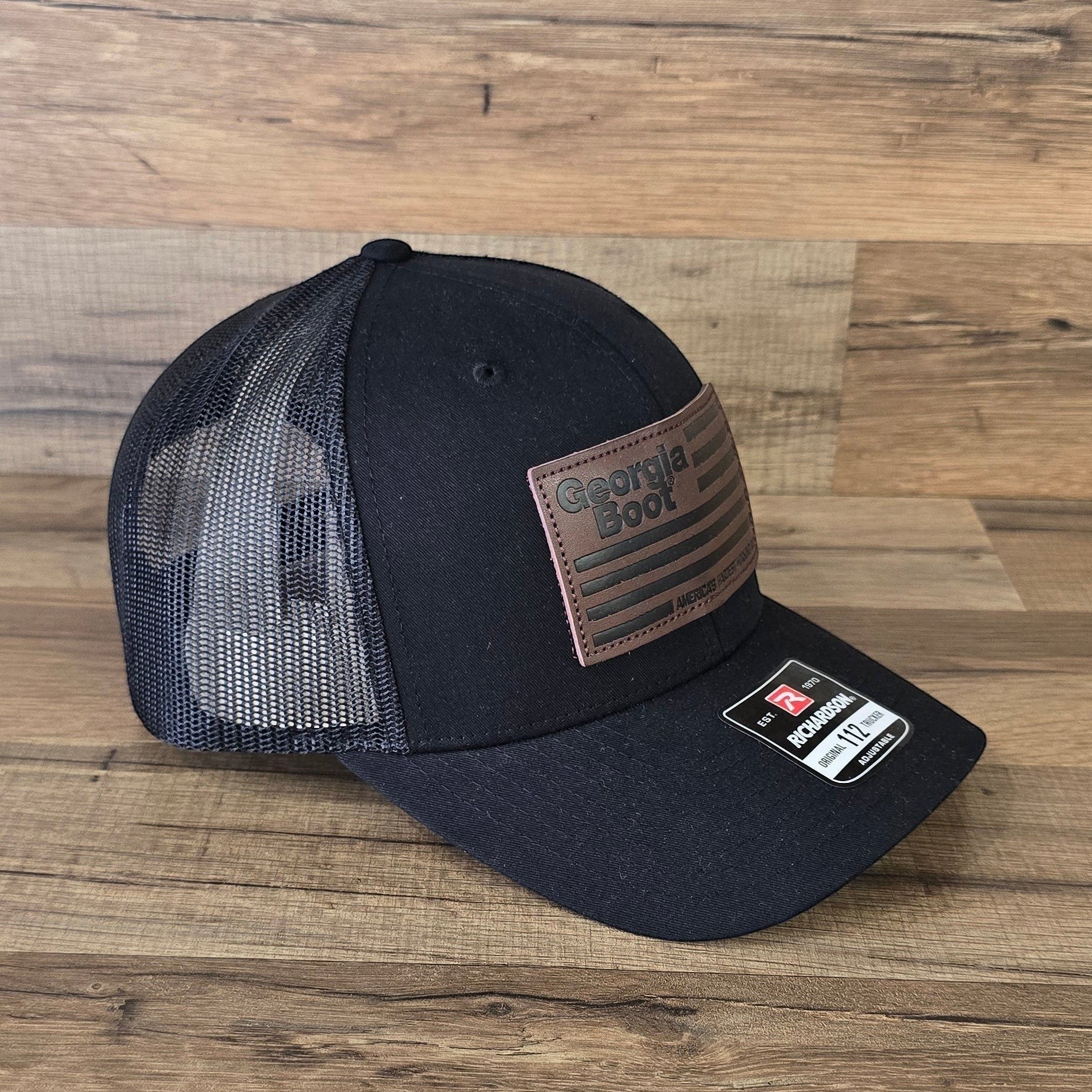 Allen's Bootery black trucker hat with a leather Georgia Boot flag patch and breathable mesh back.