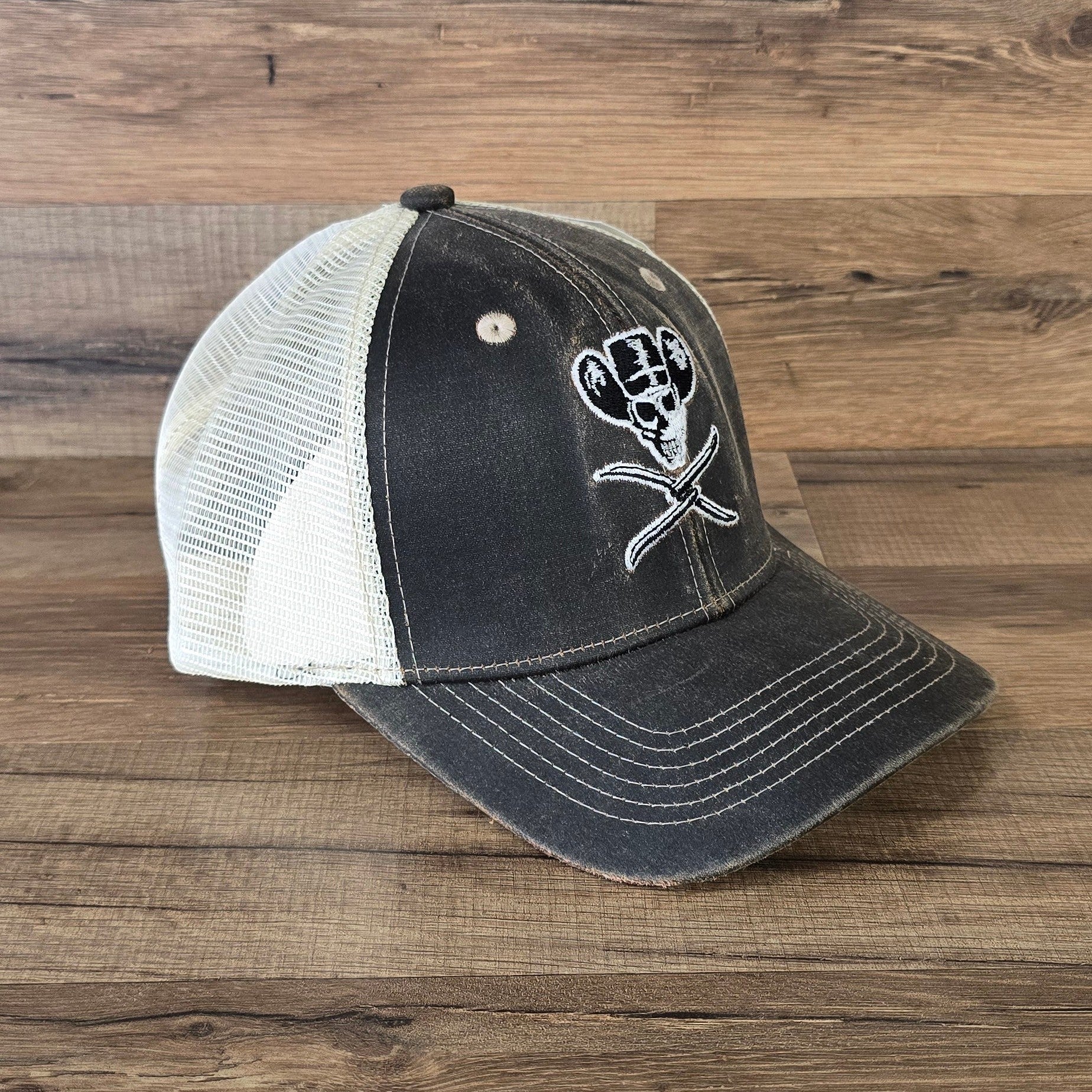 Allen's Bootery brown distressed mesh hat featuring a white cowboy skull logo and adjustable hook and loop closure.