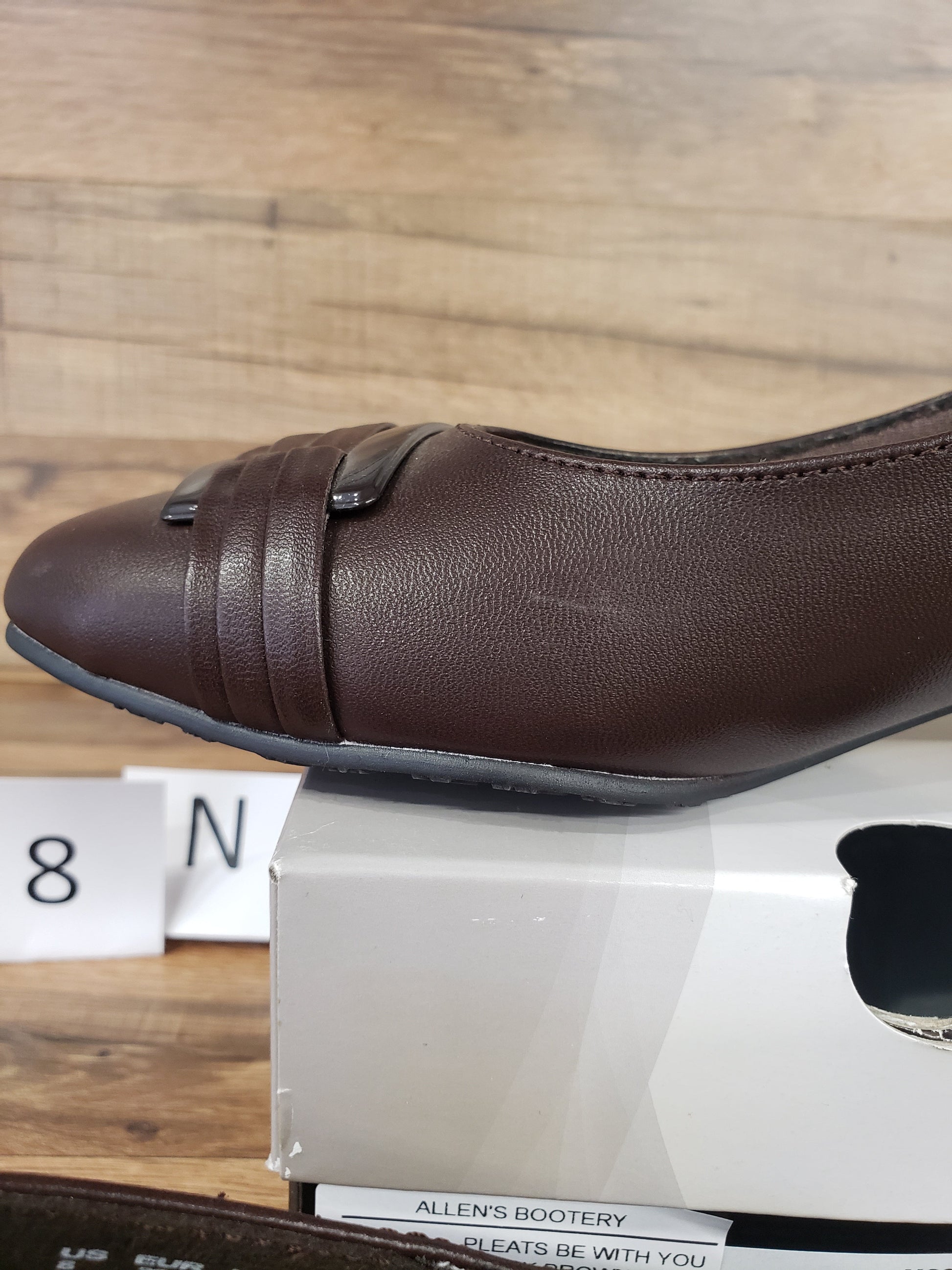 Allen's Bootery dark brown Pleats Be With You closed-toe pump with pleated toe detail and patent buckle accent