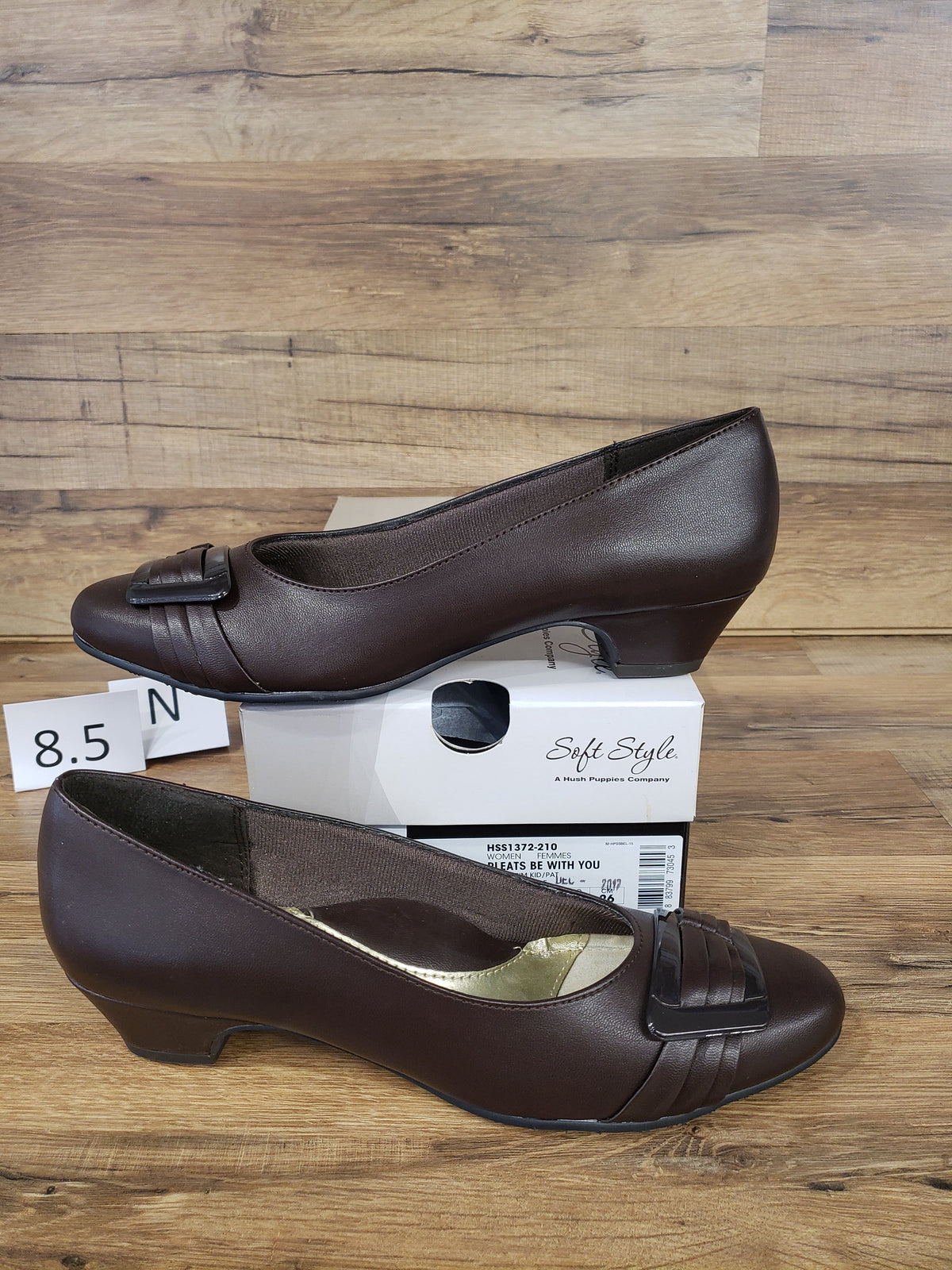 Allen's Bootery dark brown closed-toe pumps with pleated toe detail, buckle ornament, and low block heel.