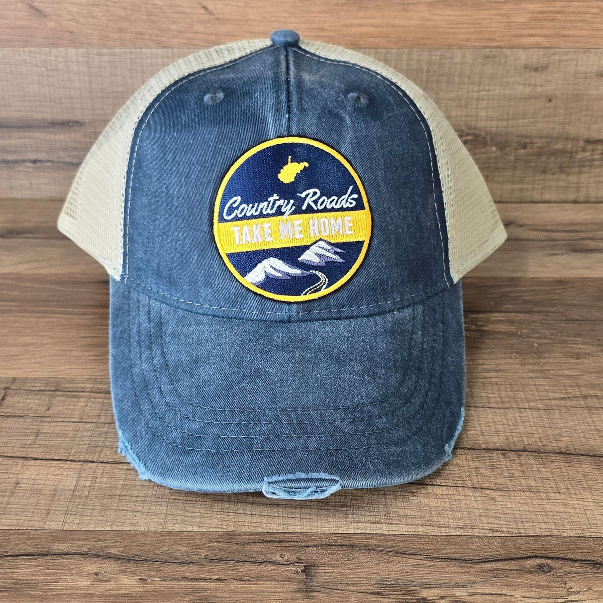 Allen's Bootery distressed blue trucker hat with tan mesh back and Country Roads mountain landscape patch