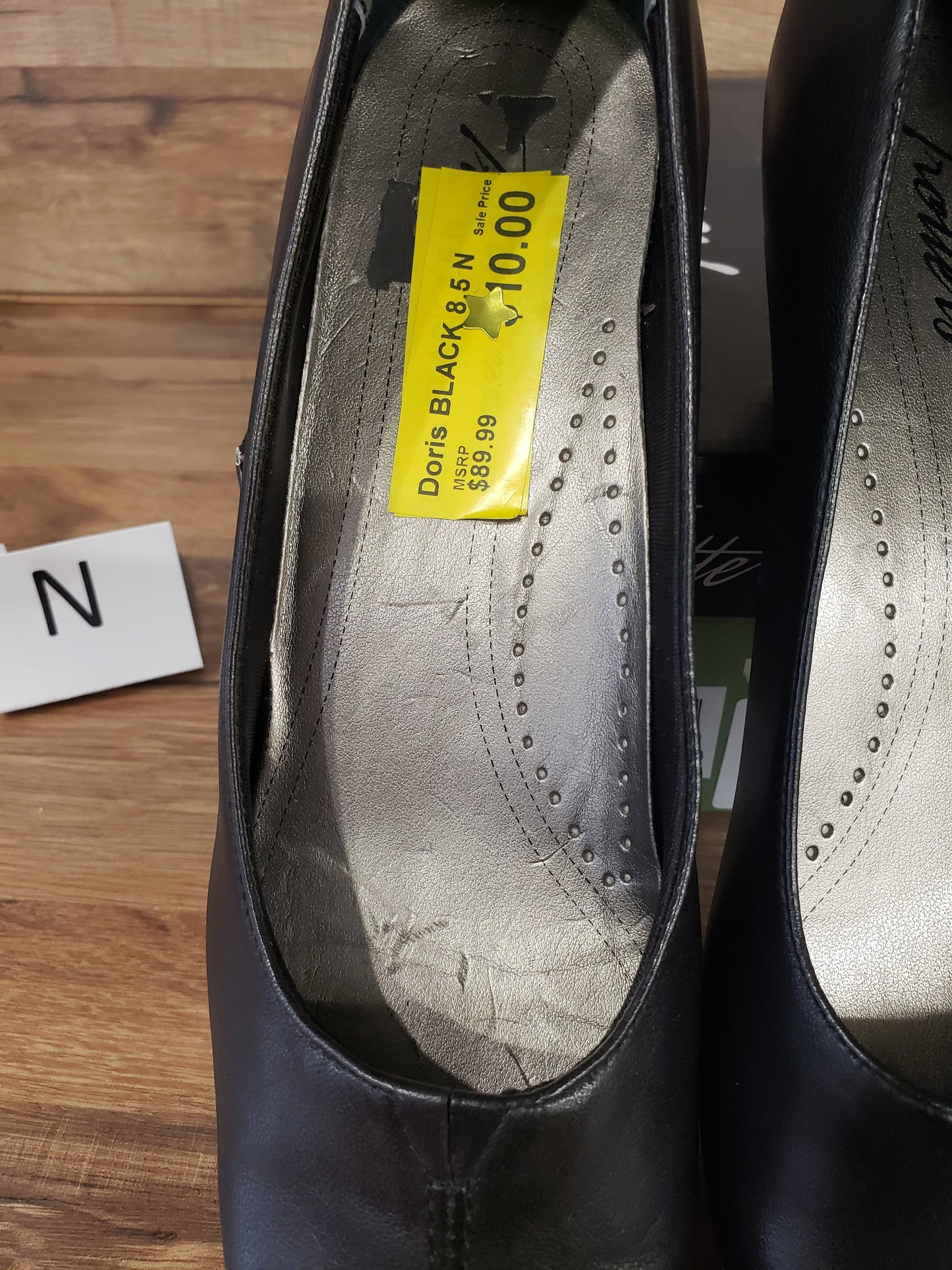 Allen's Bootery Doris black pumps with cushioned silver footbeds and v-gore detail on a wooden surface.