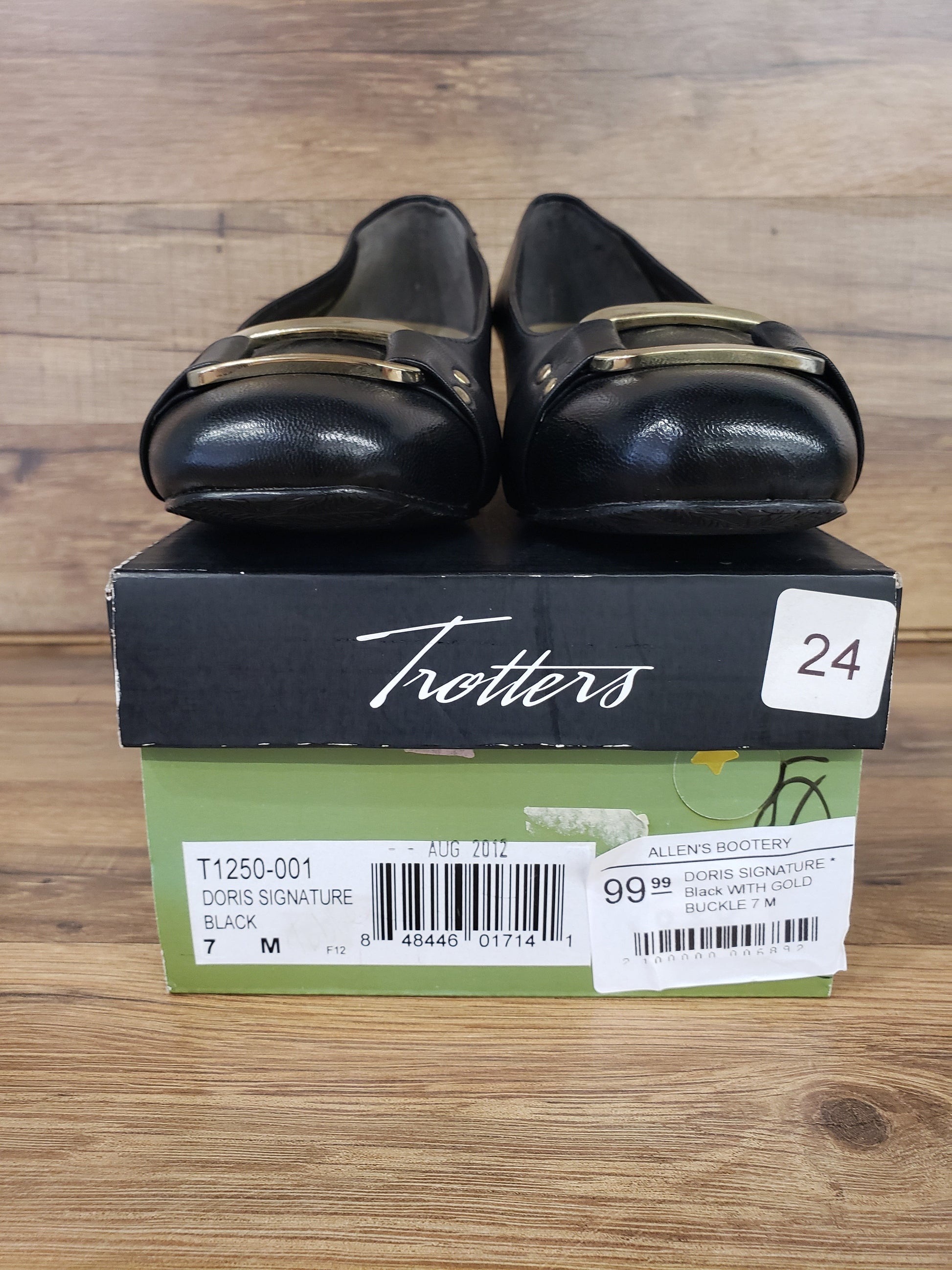 Allen's Bootery Trotters Doris Signature black dress shoes with gold buckle detail resting on their original box
