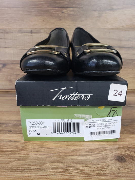 Allen's Bootery Trotters Doris Signature black dress shoes with gold buckle detail resting on their original box