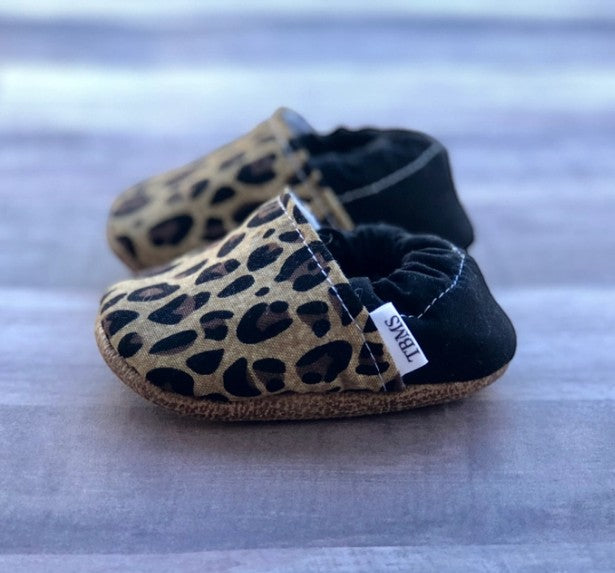 Allen's Bootery leopard print infant moccasins with black heels and soft flexible soles for babies.