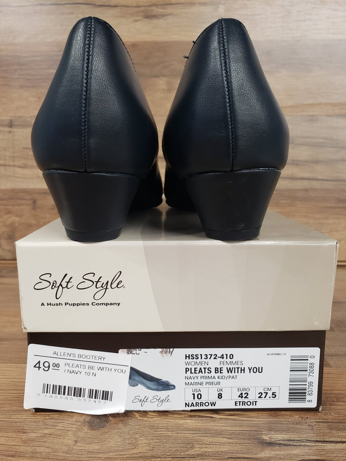 Allen's Bootery Soft Style navy blue closed-toe pumps with low heels, shown from the back on top of the shoe box.