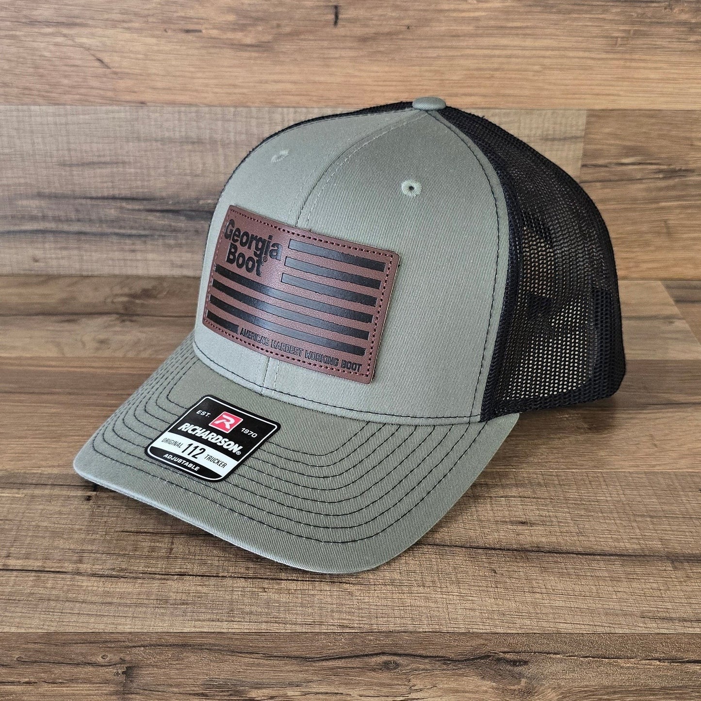 Allen's Bootery olive green and black mesh trucker hat with a leather Georgia Boot flag patch on the front.