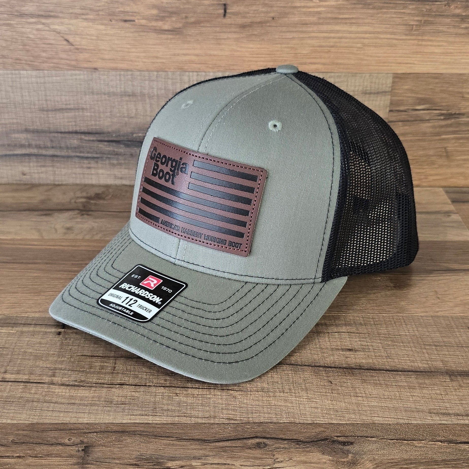 Allen's Bootery olive green and black mesh trucker hat with a leather Georgia Boot flag patch on the front.