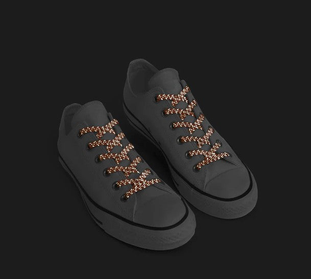 Allen's Bootery Xpand no-tie elastic laces in high-visibility orange reflective material on grey sneakers.