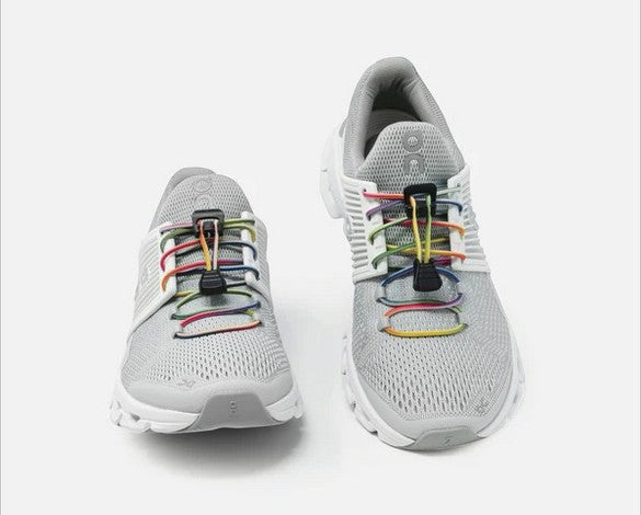 Allen's Bootery Xpand Laces quick release rainbow elastic laces installed on grey athletic sneakers