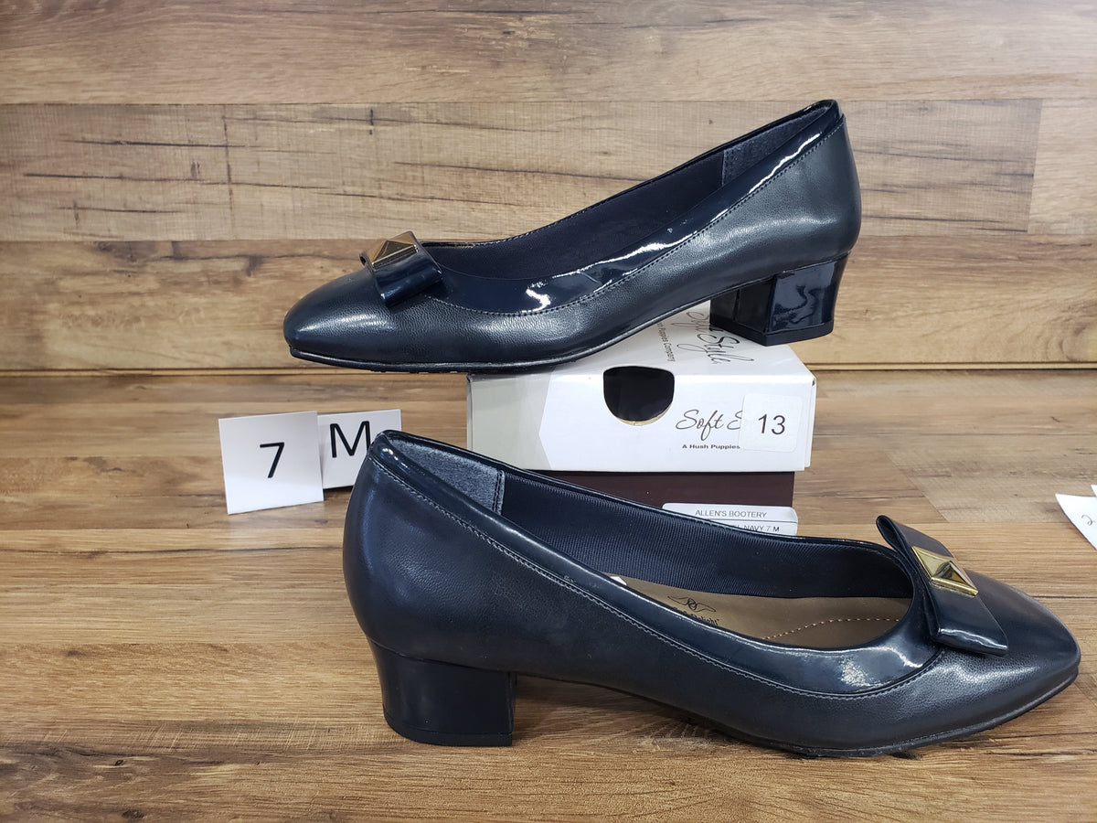 Allen's Bootery Santel navy cap toe pumps featuring a low block heel and a decorative gold-tone metal ornament.