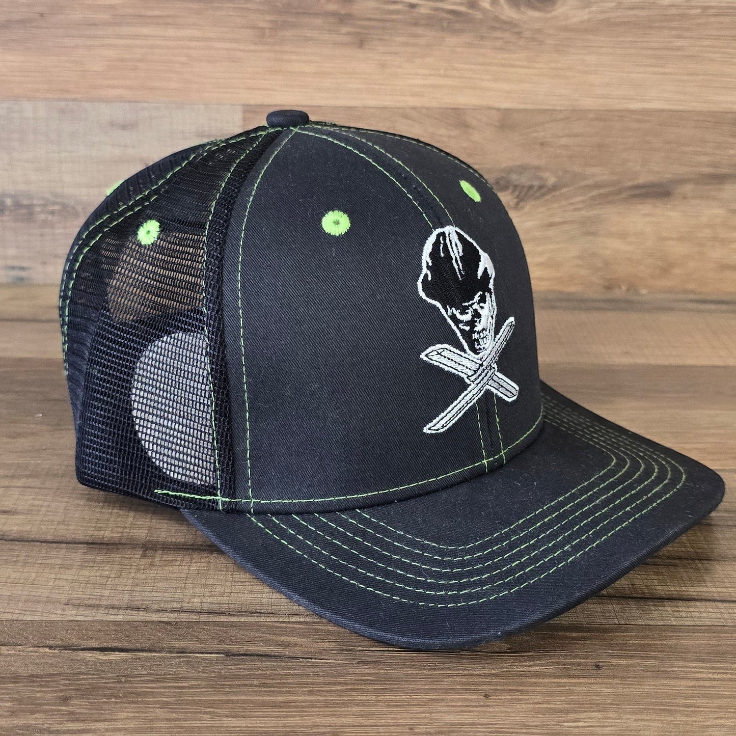 Allen's Bootery Twisted X black mesh hat with lime green stitching and an embroidered skull and cross-tool graphic.