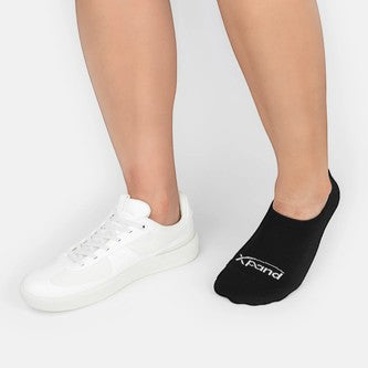 Allen's Bootery Xpand black no-show socks with ergonomic cushioning and anti-slip heel lock worn with white sneakers.