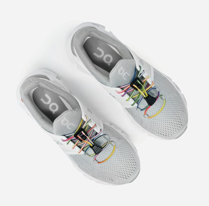 Allen's Bootery Xpand Laces Quick Release in rainbow on grey athletic sneakers for a slip-on fit.