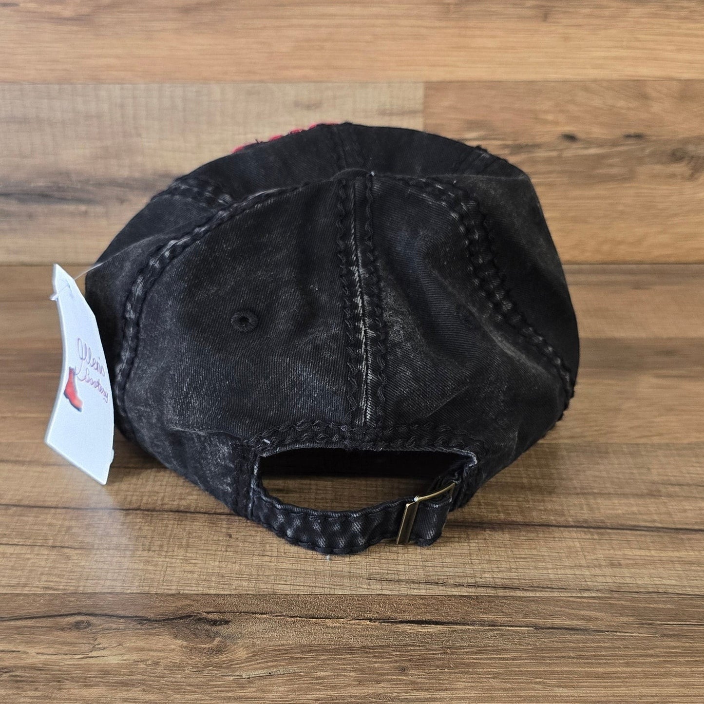 Allen's Bootery black washed-cotton baseball cap with adjustable metal buckle strap and distressed finish.