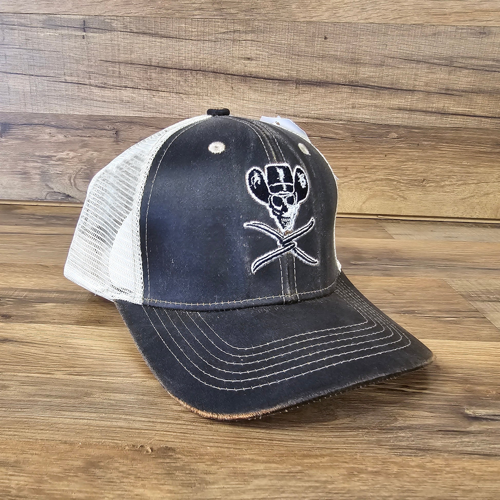 Allen's Bootery brown and white mesh trucker hat featuring a distressed skull and cowboy hat embroidery.