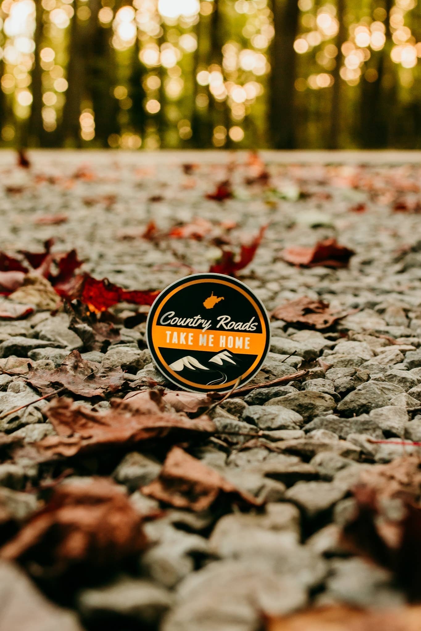 Allen's Bootery Country Roads sticker featuring mountain graphics on a gravel path with autumn leaves.