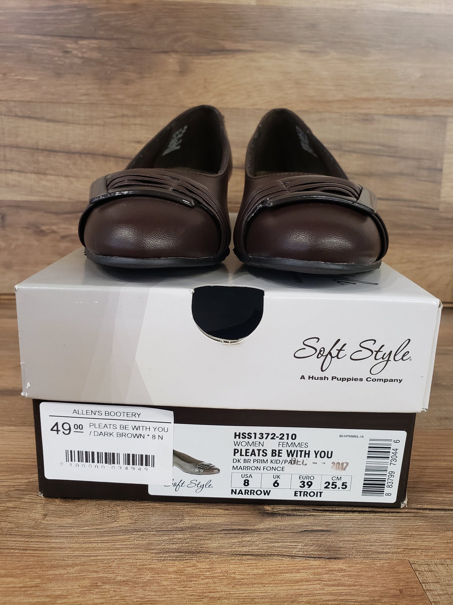 Allen's Bootery dark brown Pleats Be With You round toe pumps with buckle detail on top of the shoe box