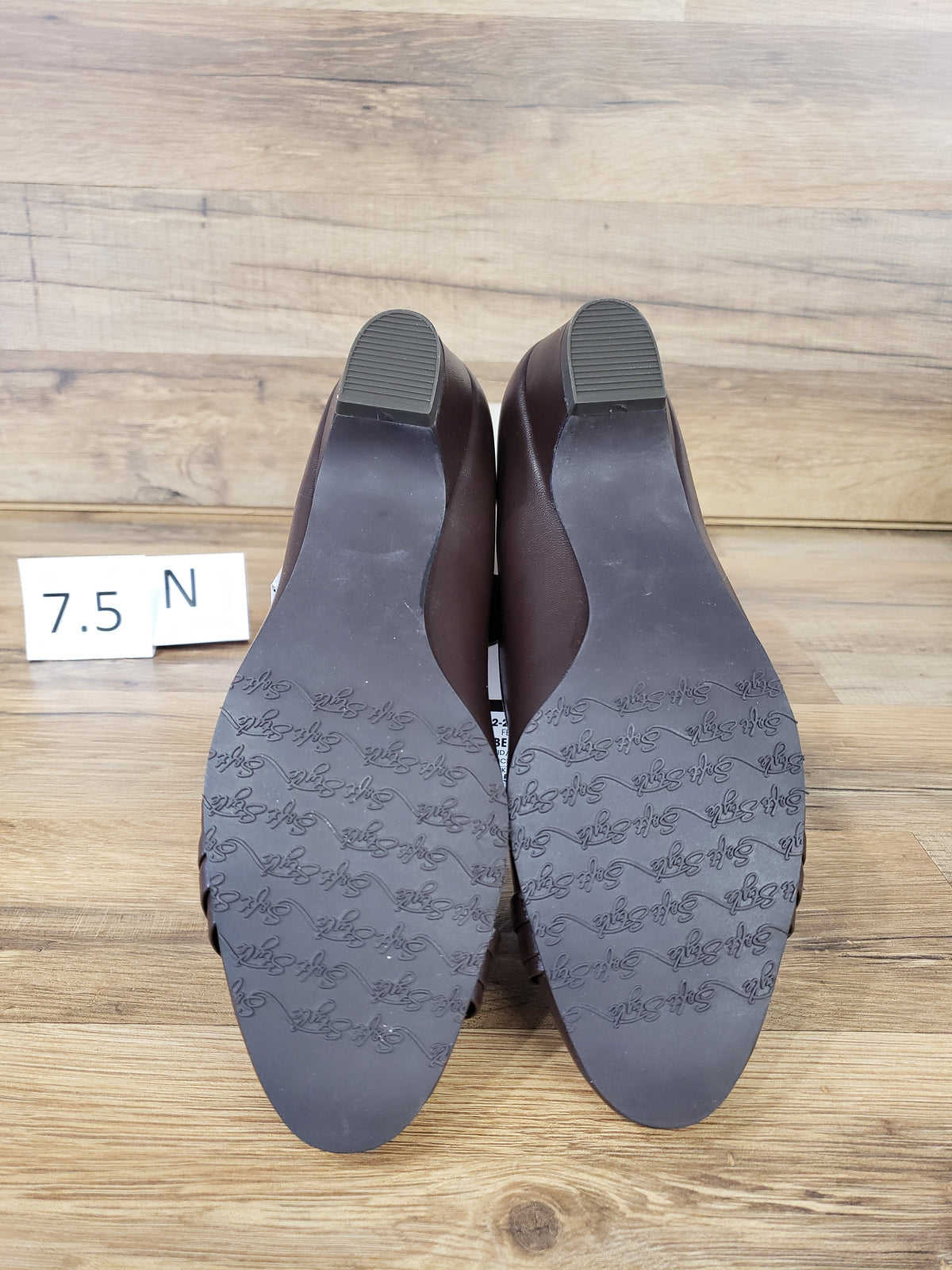 Allen's Bootery dark brown closed-toe pumps with molded rubber outsoles showing traction pattern, back view
