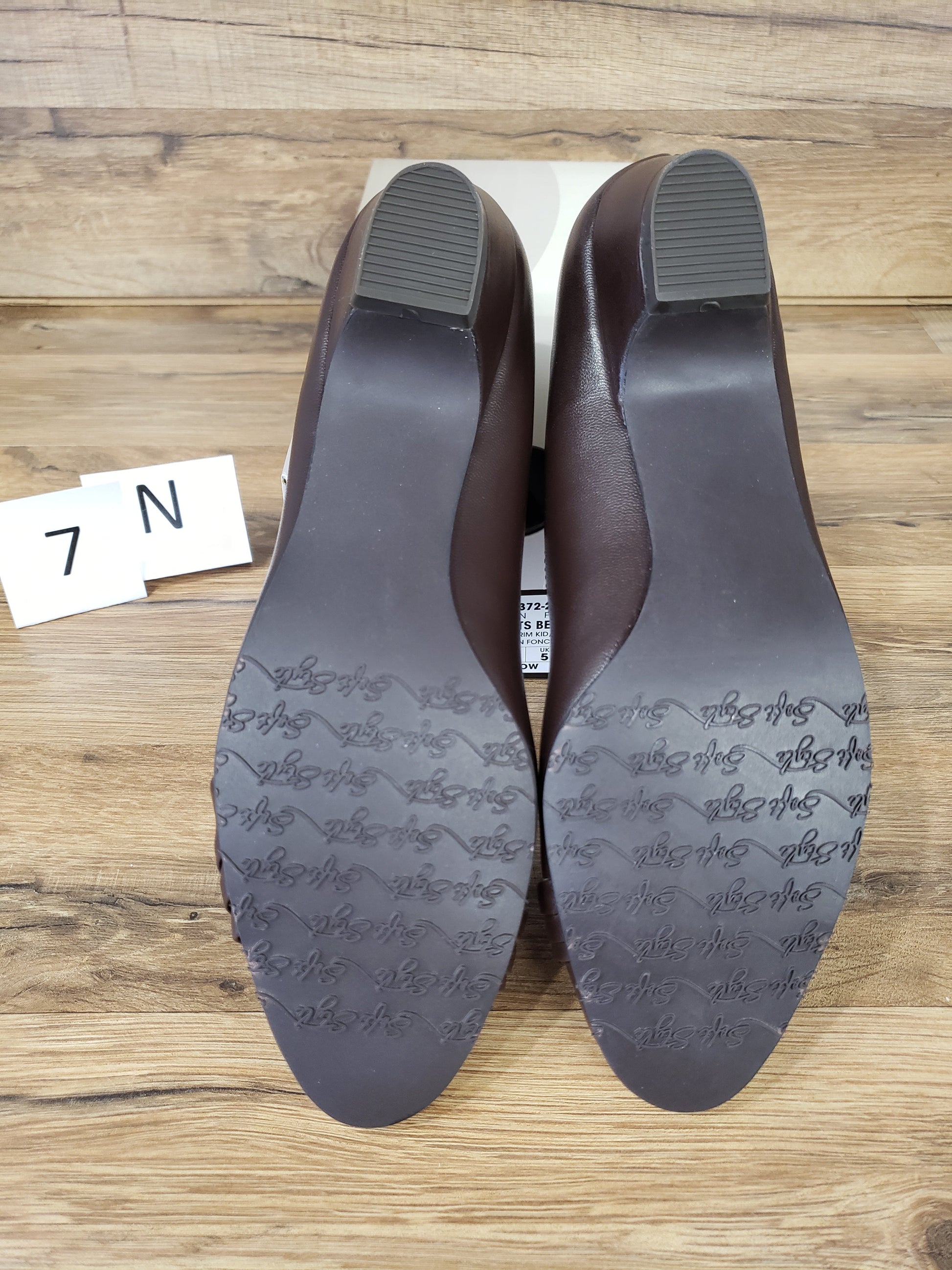 Allen's Bootery dark brown closed-toe pumps showing the textured rubber outsoles and low heels
