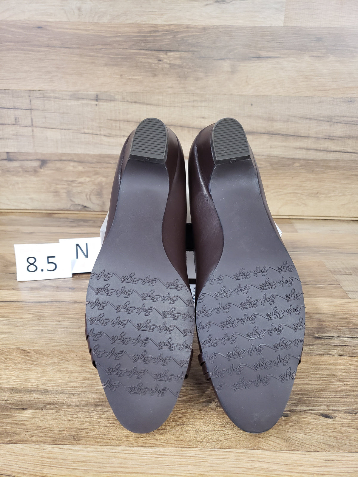 Allen's Bootery dark brown closed-toe pumps showing the molded rubber outsoles with textured grip pattern