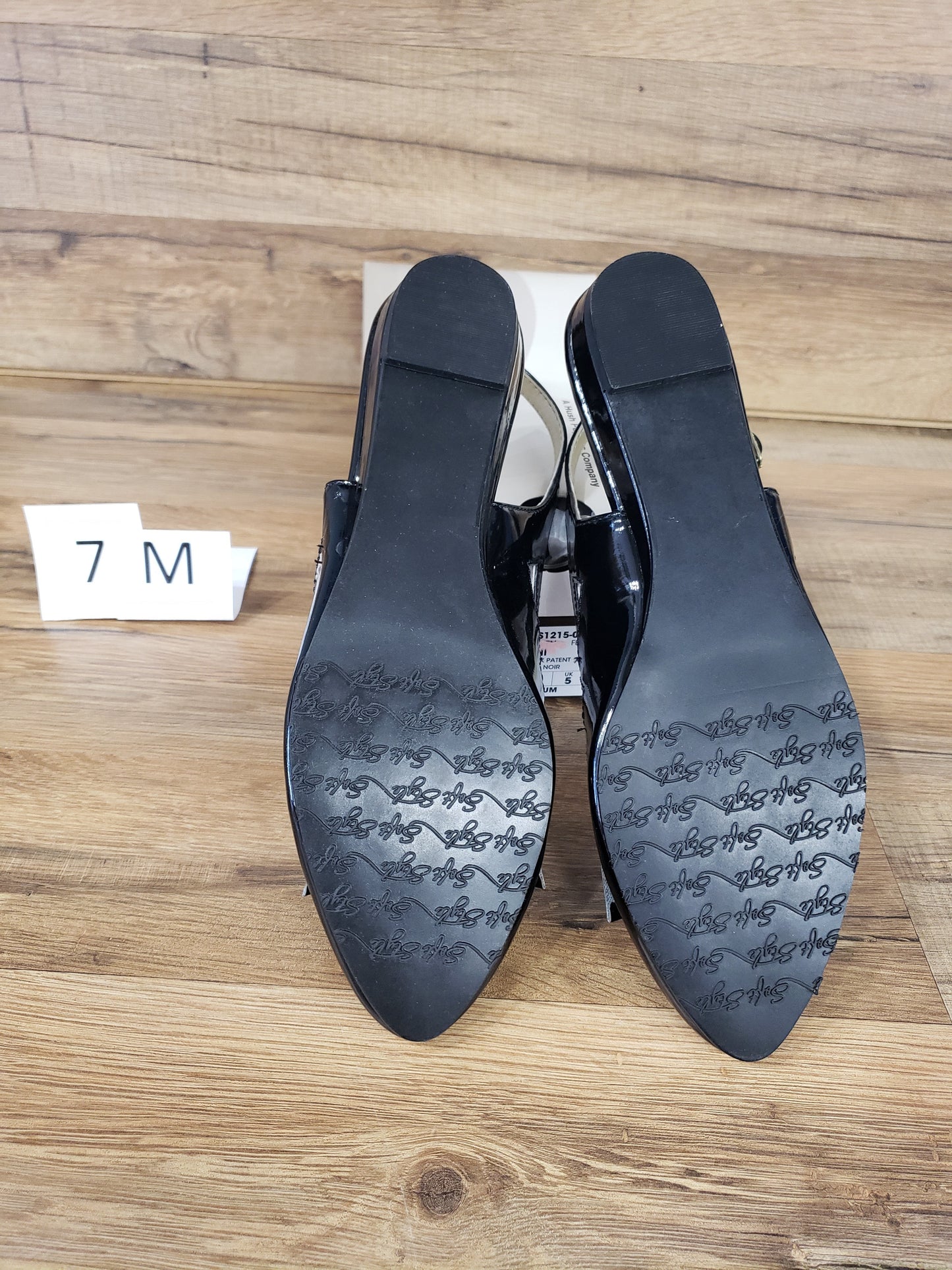 Allen's Bootery Deni black patent flat dress shoes showing the textured rubber soles and low wedge heels.