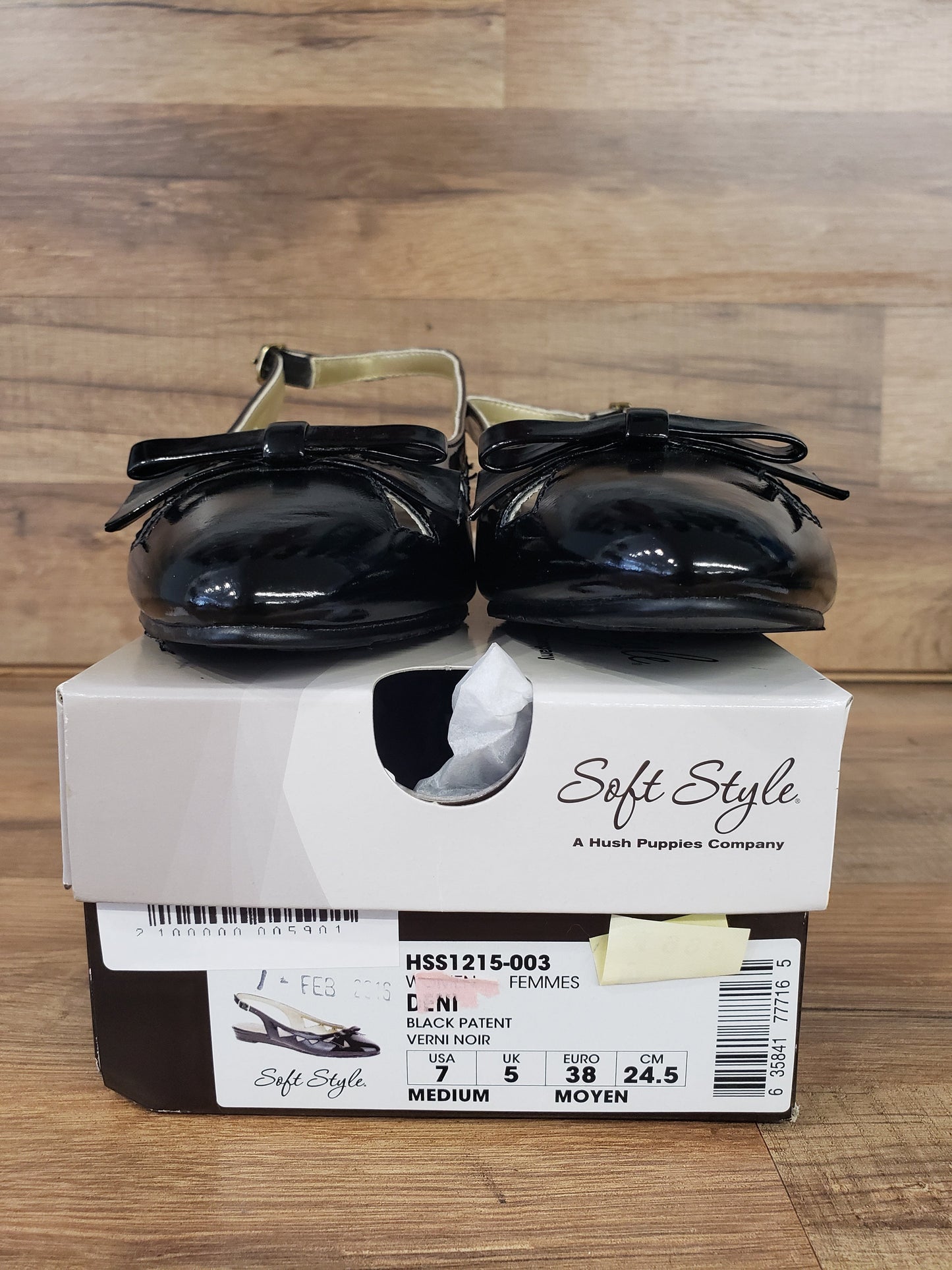Allen's Bootery Deni black patent flat dress shoes with bow detail and buckle closure on top of the original box.