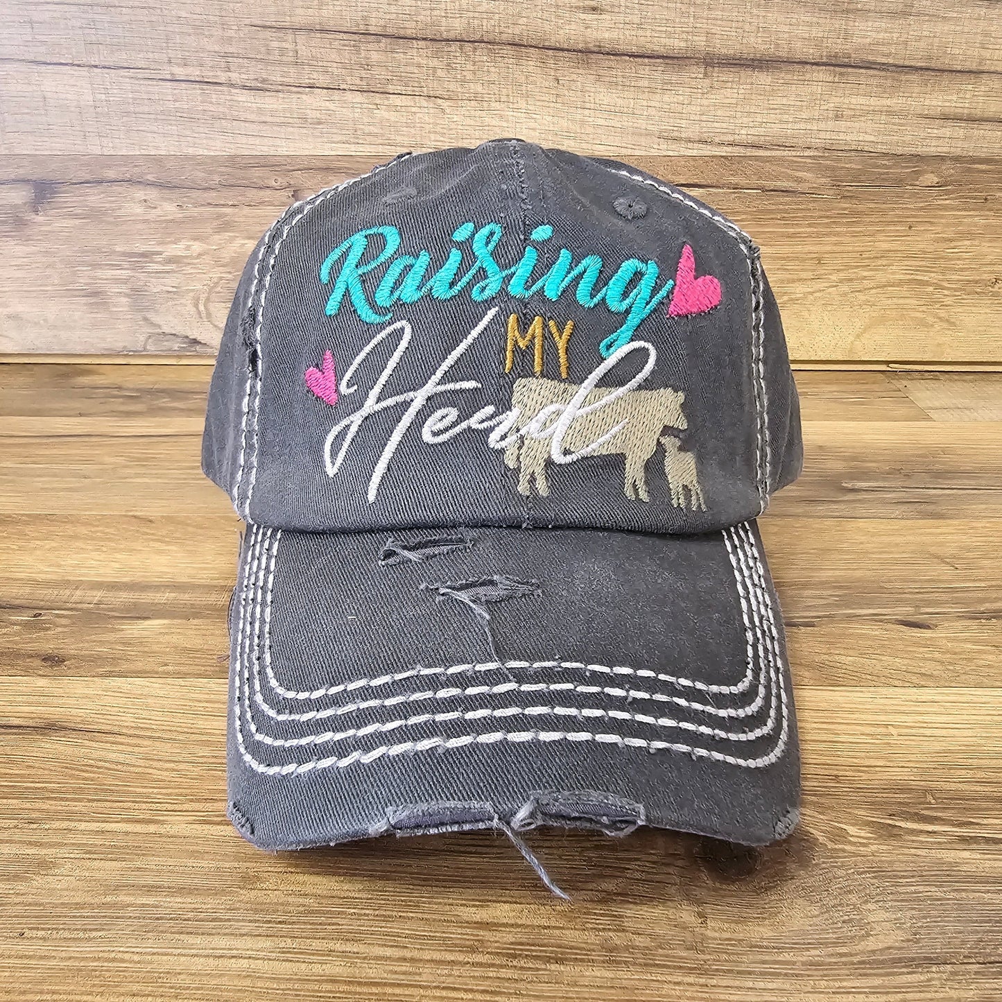 Allen's Bootery distressed charcoal grey baseball cap with Raising My Herd embroidery and cow and calf graphic.