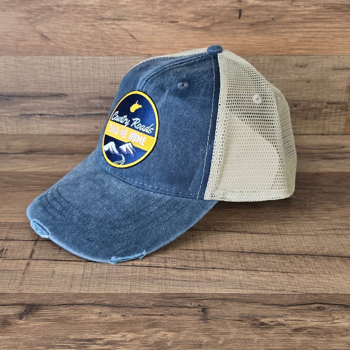 Allen's Bootery distressed blue trucker hat with a Country Roads mountain landscape patch and tan mesh back.