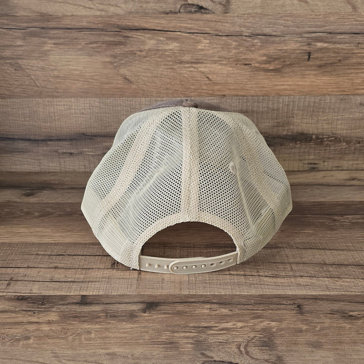 Allen's Bootery distressed trucker hat with a beige mesh back and adjustable snapback closure, rear view.
