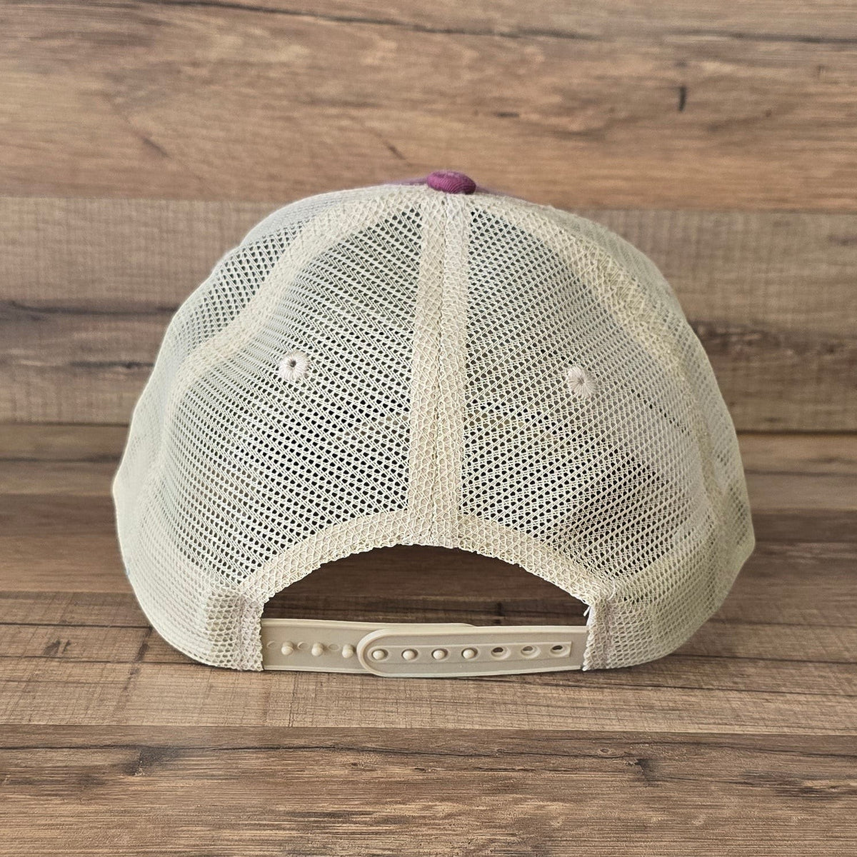 Allen's Bootery distressed trucker hat with a cream mesh back and adjustable snapback closure, rear view.