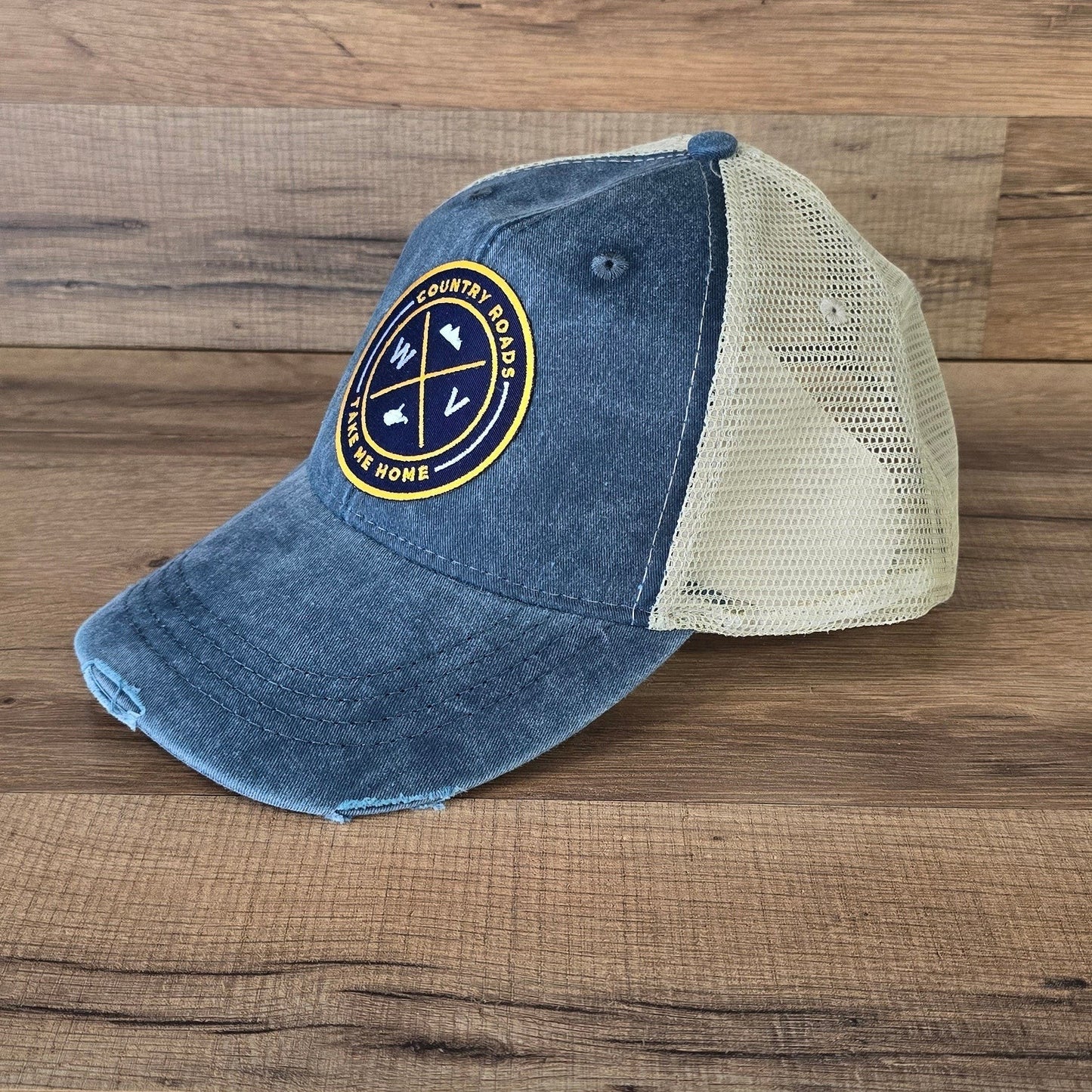 Allen's Bootery distressed blue and beige mesh trucker hat with a circular WV Country Roads patch