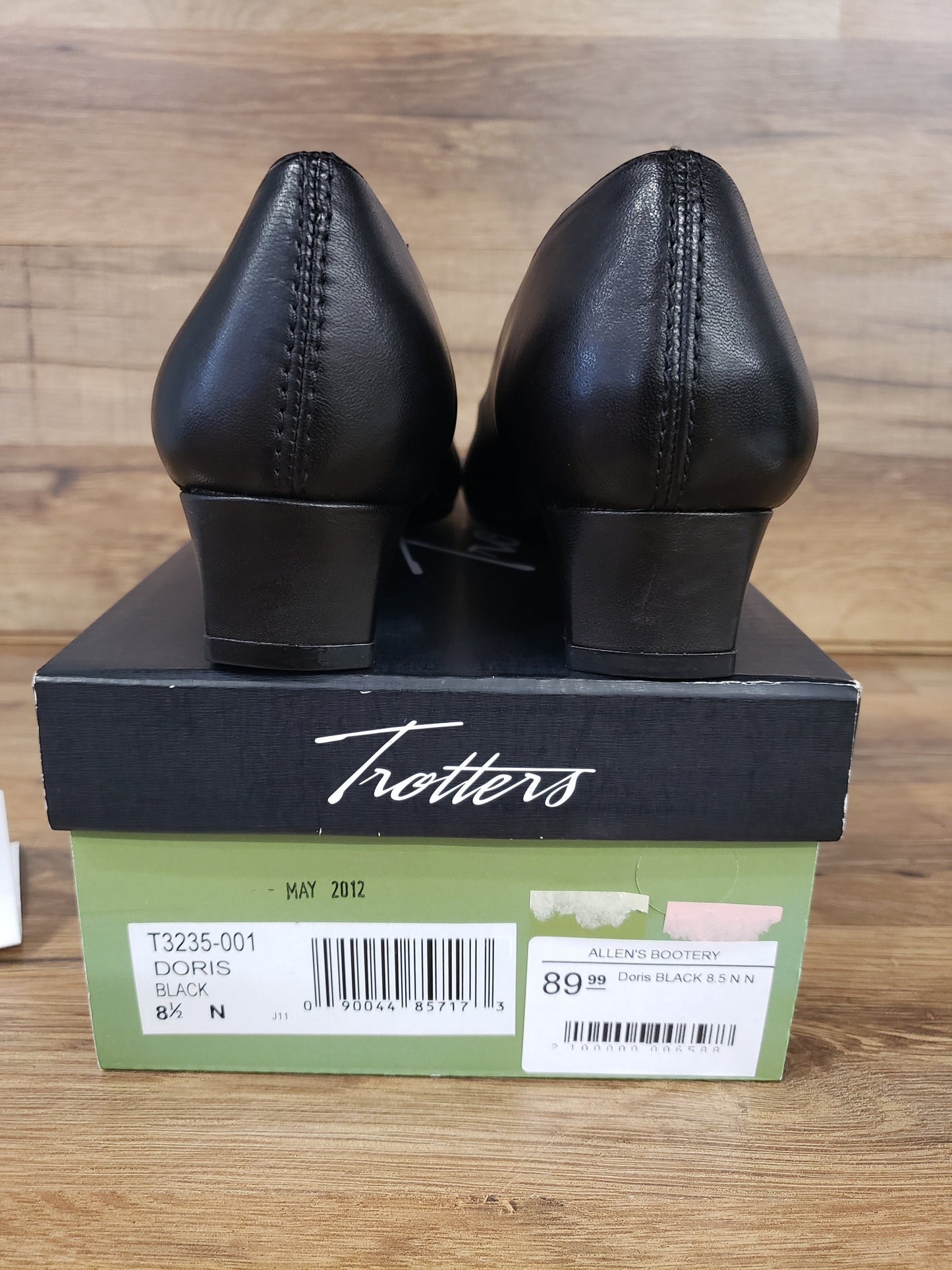 Allen's Bootery Doris black leather low heel pumps viewed from the back resting on their original Trotters shoe box.