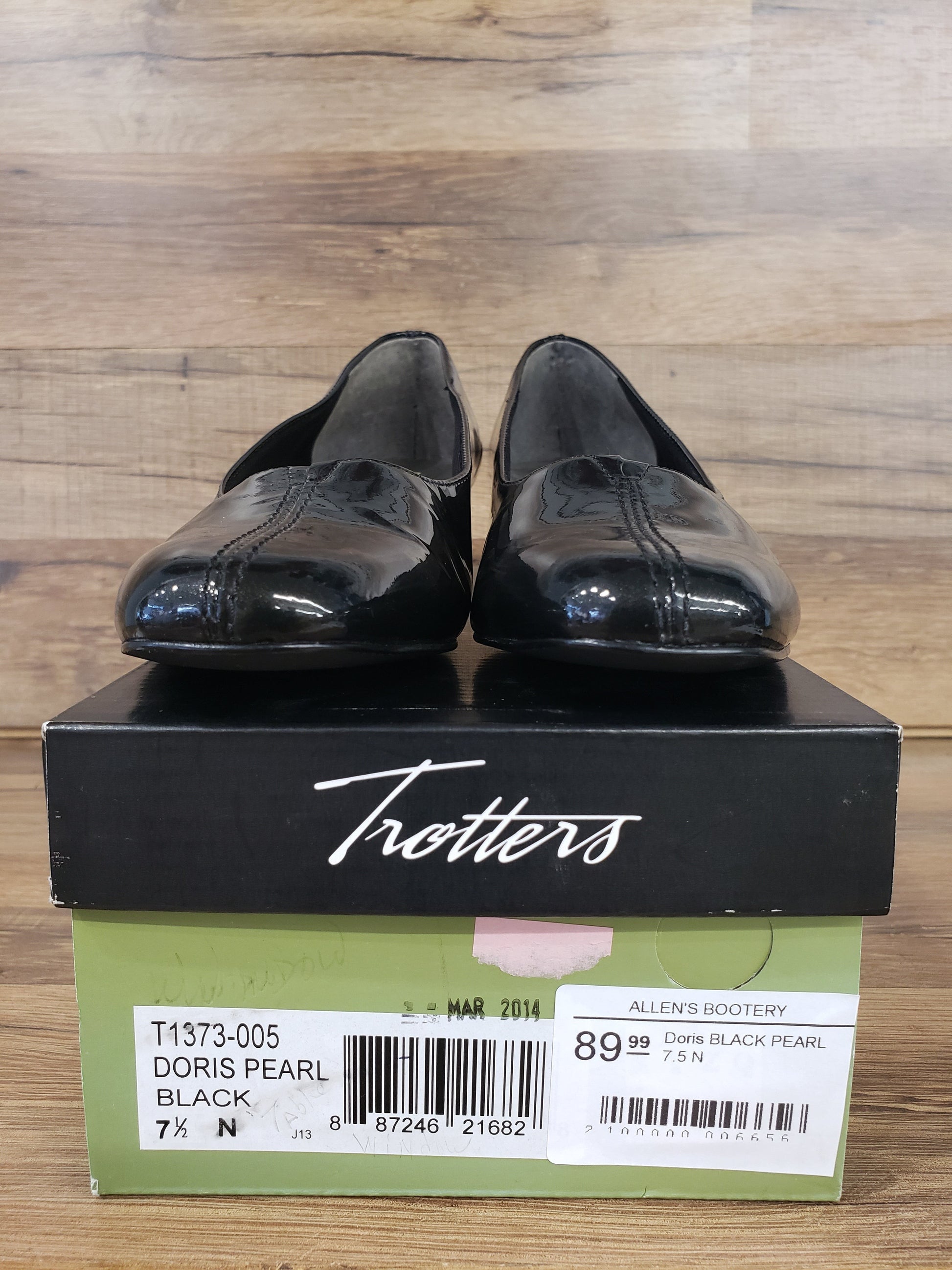 Allen's Bootery Doris black pearl patent leather low heel pumps with center v-gore detail displayed on their shoe box
