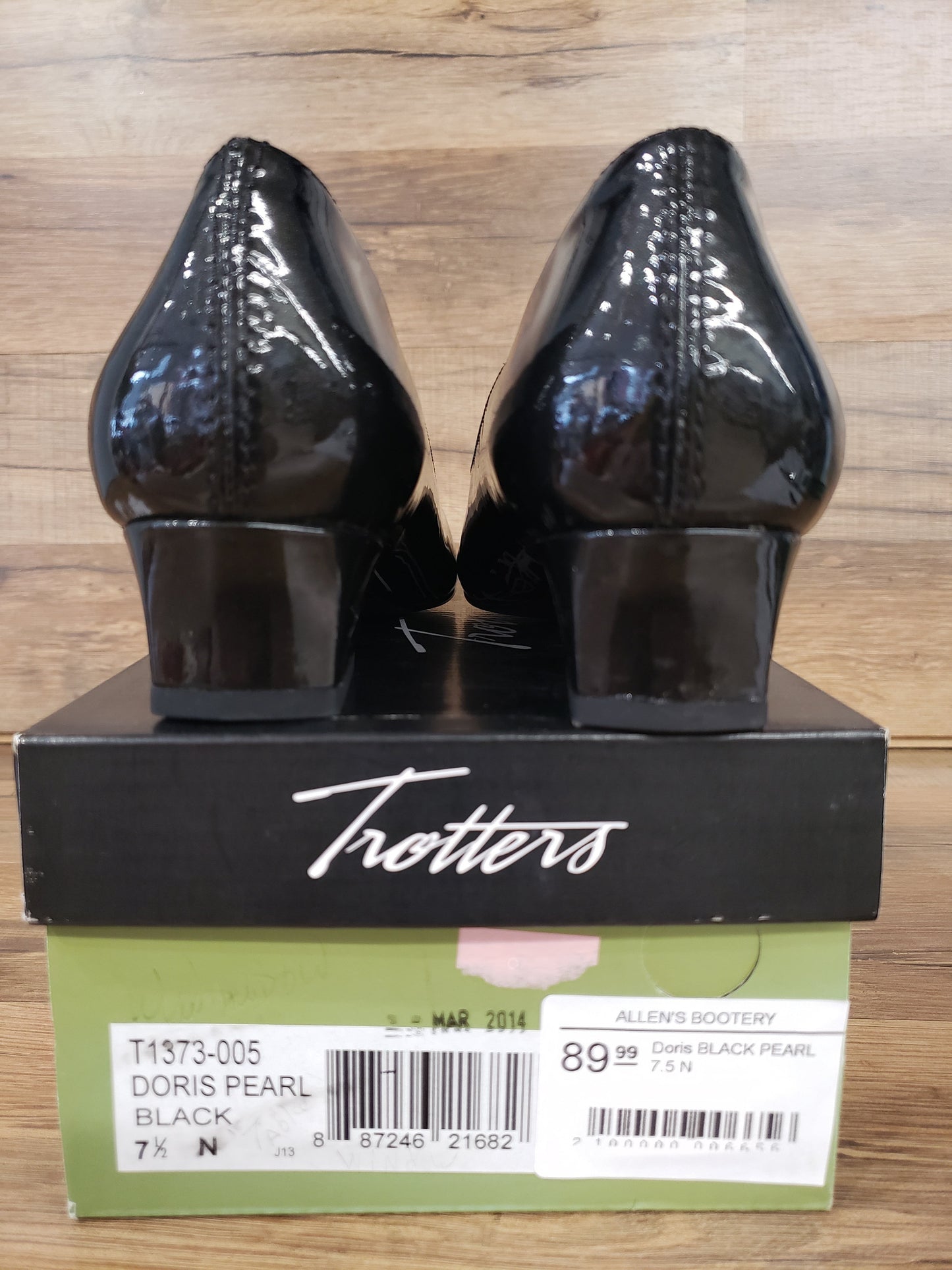 Allen's Bootery Doris black pearl patent leather pumps with low heels, shown from the back on their original box.