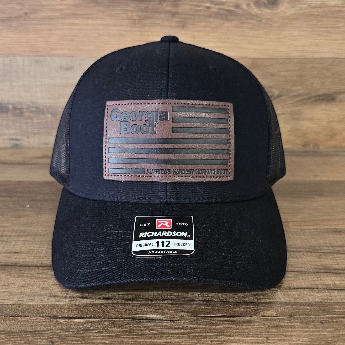 Allen's Bootery black Georgia Boot trucker hat with a brown leather flag patch and mesh back