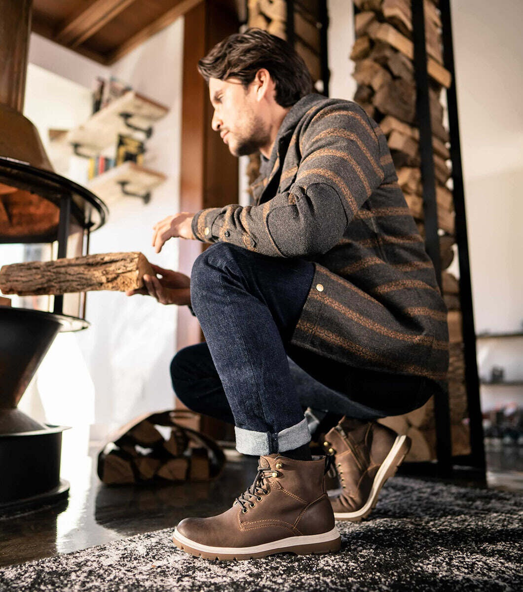 Allen's Bootery Lookout light brown plain toe lace-up boots with side zipper worn by a man by a fireplace