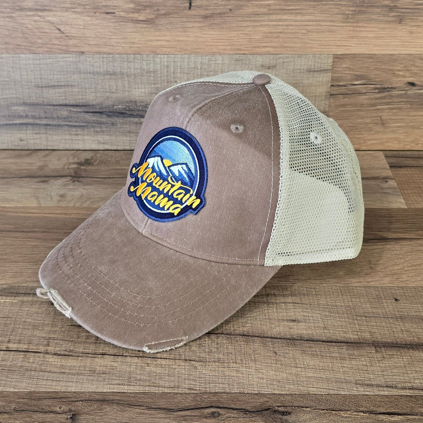 Allen's Bootery Mountain Mama trucker hat in brown with a distressed brim, mesh back, and embroidered mountain patch.