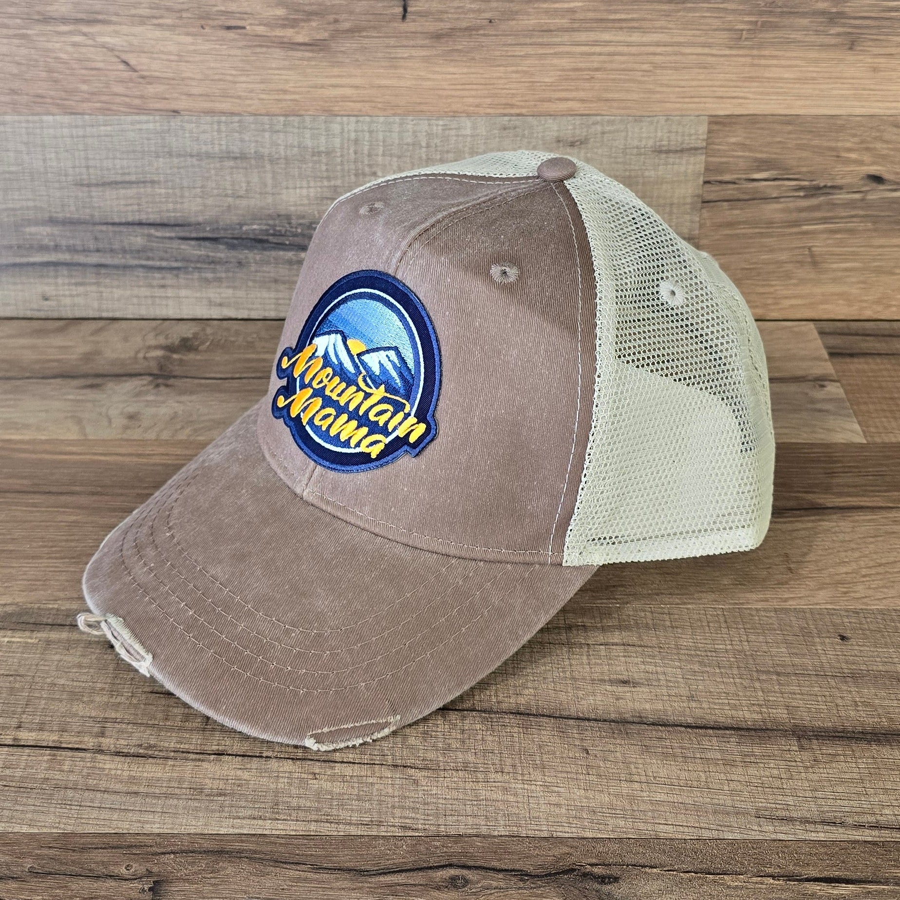 Allen's Bootery Mountain Mama trucker hat in brown with a distressed brim, mesh back, and embroidered mountain patch.
