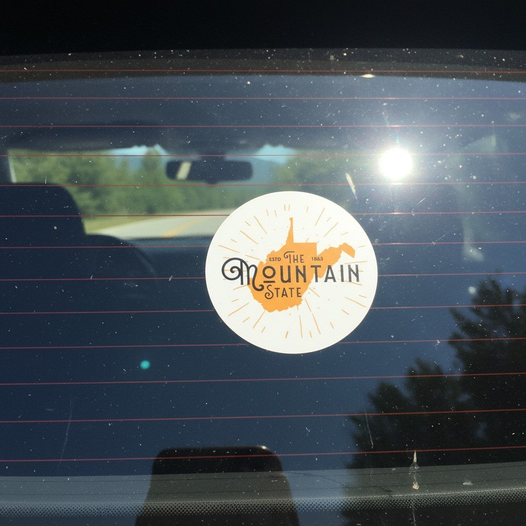 Allen's Bootery The Mountain State circular sticker with orange West Virginia map design on a car window