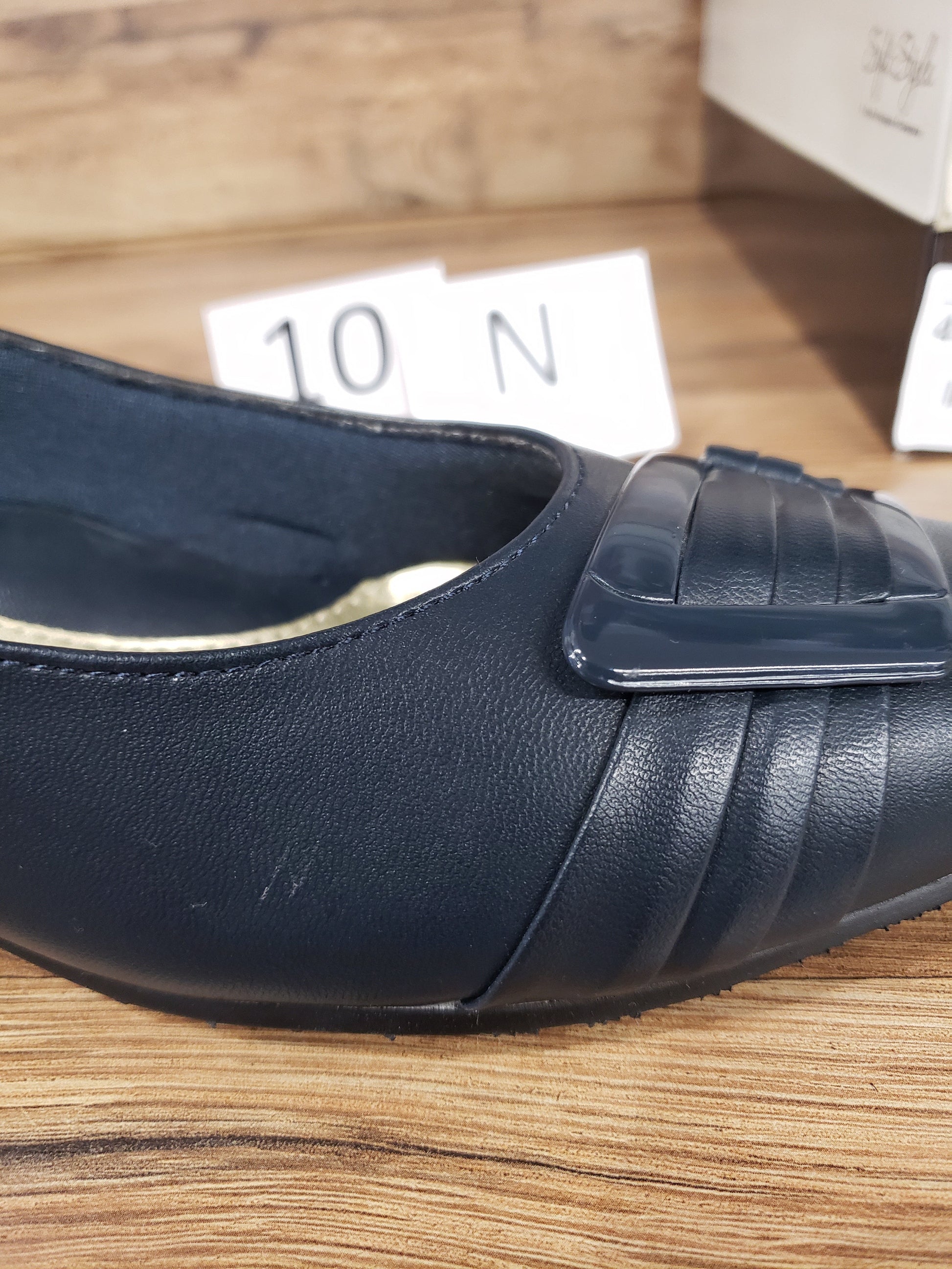 Allen's Bootery navy blue closed-toe pump with pleated toe detail, buckle ornament, and memory foam footbed