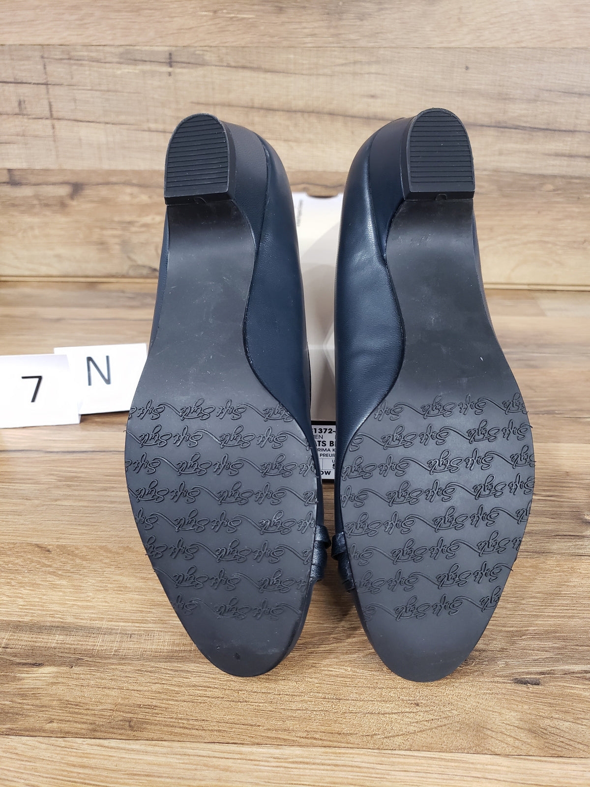 Allen's Bootery navy blue pumps showing the molded rubber outsoles with traction pattern and low block heels