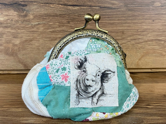 Allen's Bootery handcrafted patchwork fabric coin purse with a pig illustration and antique brass kiss-lock clasp.