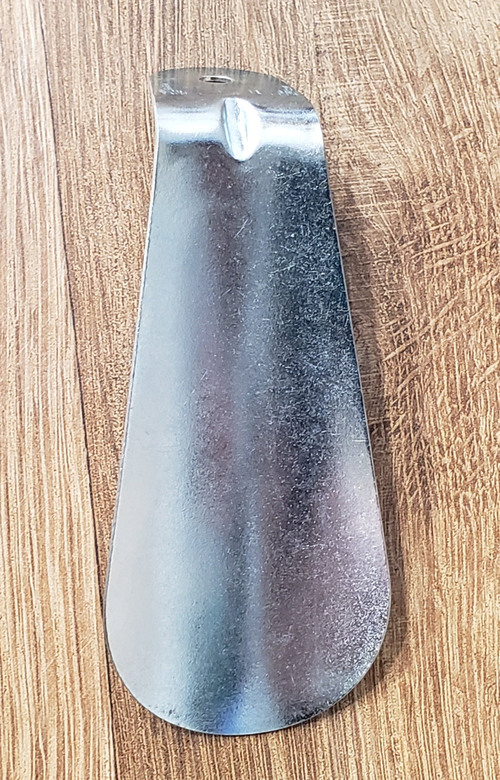 Allen's Bootery 3.5 inch silver metal shoe horn with a contoured design and hanging hole for easy storage.