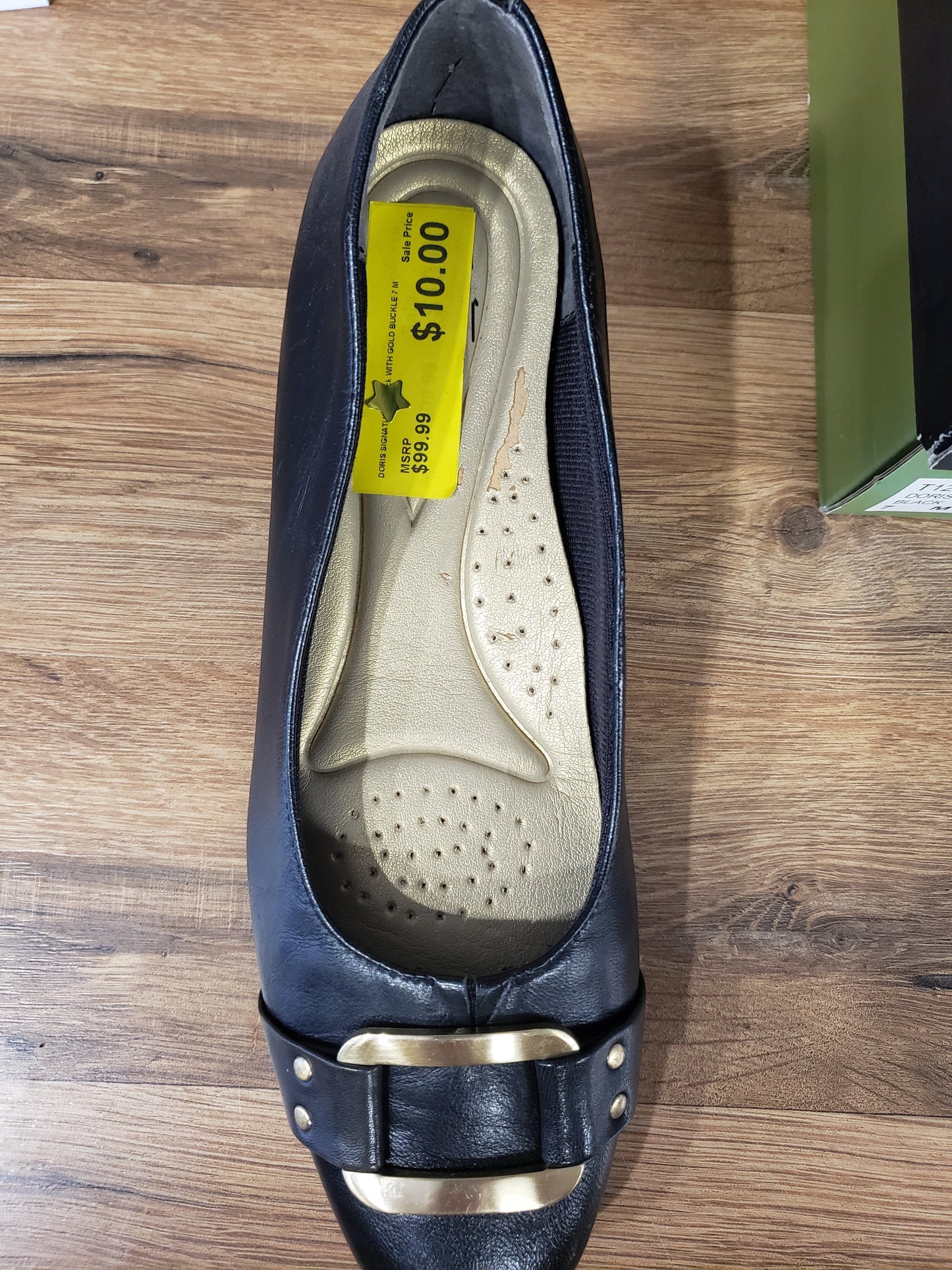 Allen's Bootery Trotters Doris black dress shoe with gold buckle and 1.25-inch heel, top-down view.