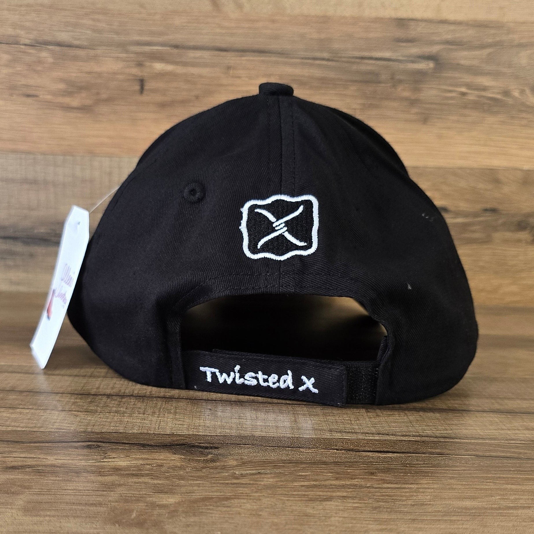 Allen's Bootery black Twisted X baseball cap showing the adjustable back strap with white embroidered logo branding.