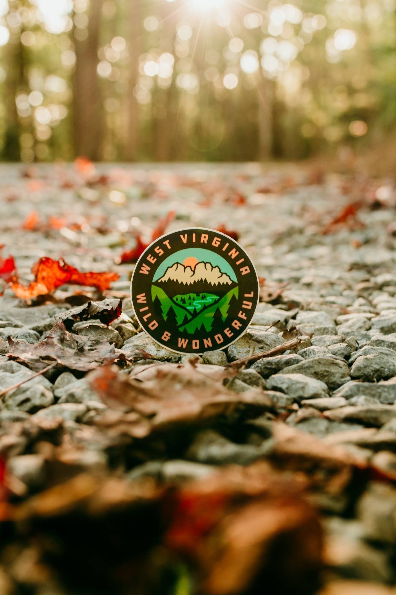 Allen's Bootery 3-inch round West Virginia scenery sticker featuring mountains and a river on a rocky forest path